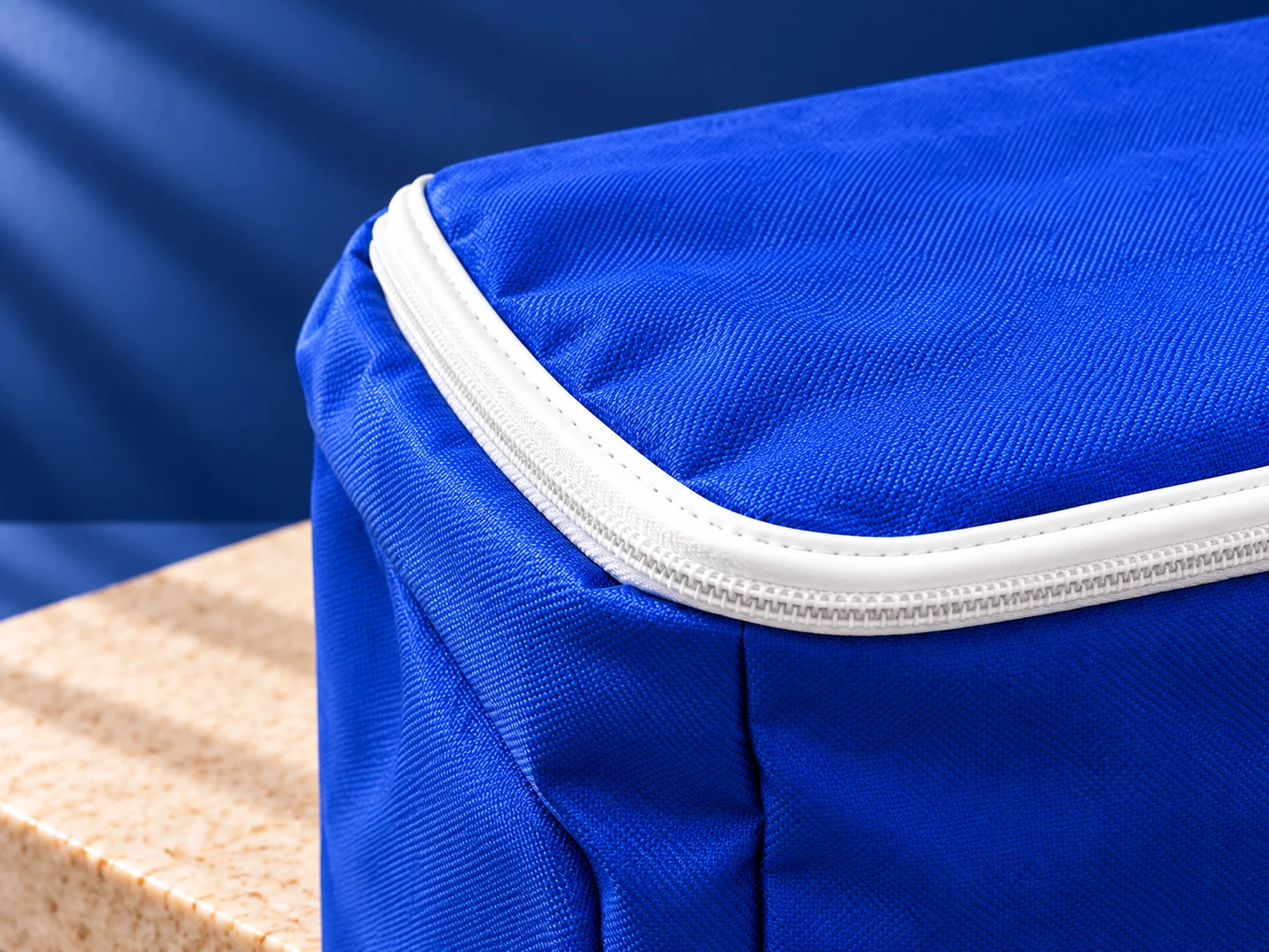 Design presentation close-up of the blue backpack zipper edge, white piping and woven fabric