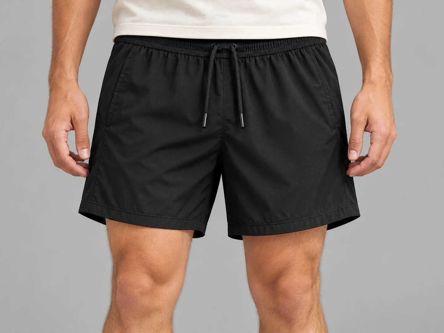 On-body fit view of plain black running shorts, cropped at waist and knees; product design concept
