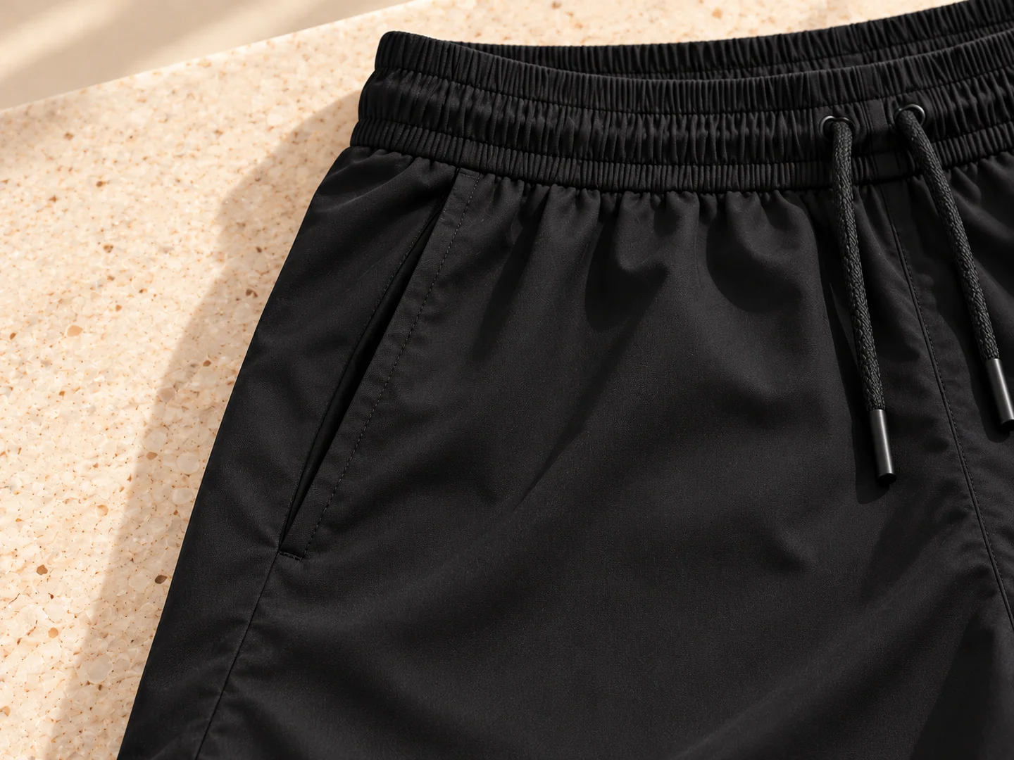 Close-up of a slanted side pocket in solid black fabric; product design concept